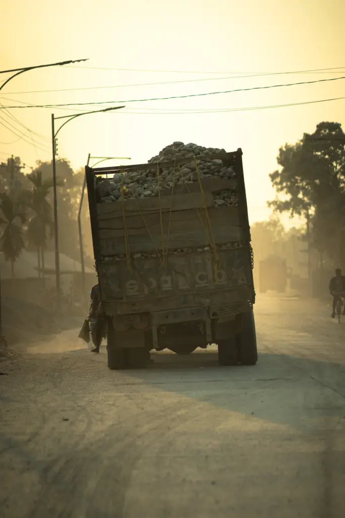 Beladener Lastwagen auf staubiger Straße · Bangladesch